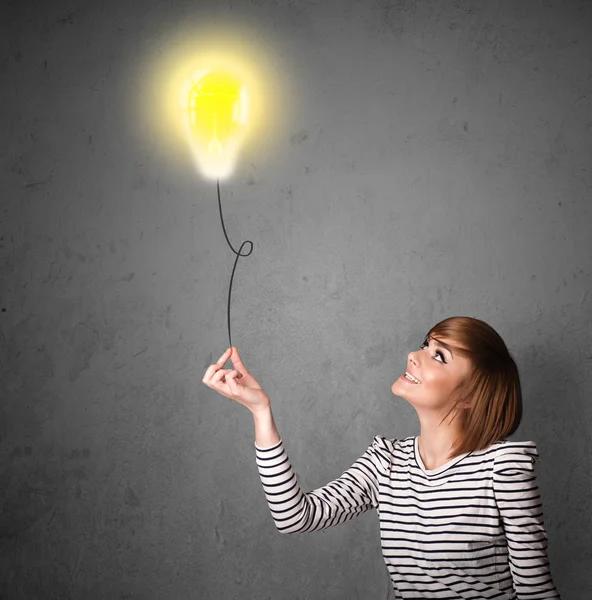 Woman holding a lightbulb balloon — Stock Photo, Image