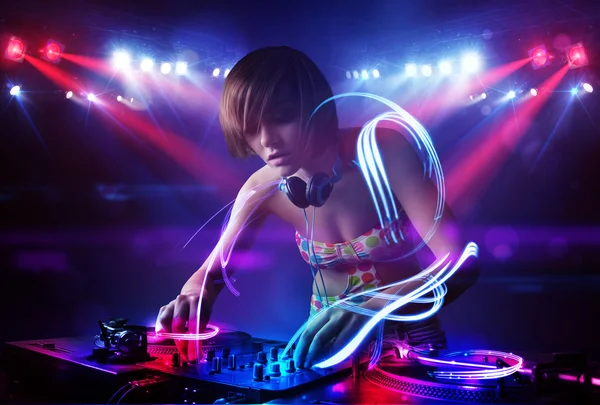 Disc jockey girl spela musik med ljusstrålen effekter på scenen — Stockfoto