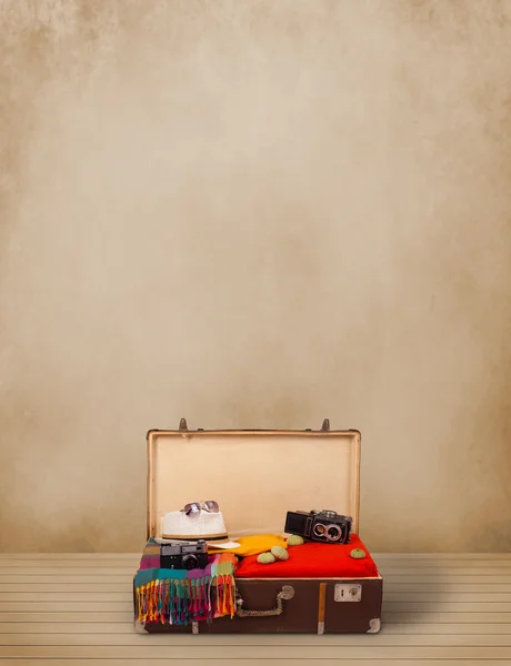 Retro tourist luggage with colorful clothes and copyspace — Stock Photo, Image