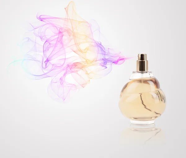 Perfume bottle spraying colored scent — Stock Photo, Image