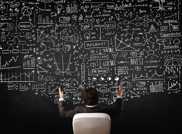 Бизнесмен сидит перед доской с картами