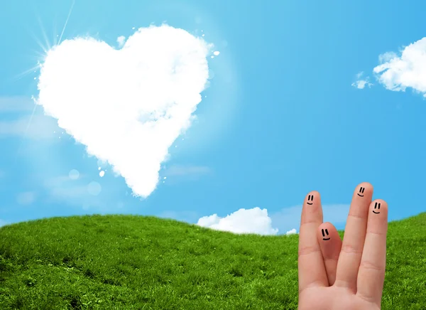 Happy smiley fingers looking at heart shaped cloud — Stock Photo, Image