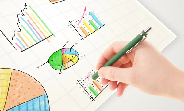 사업가가 화려 한 그래프와 성상을 종 이에 그리는 모습 — 스톡 사진