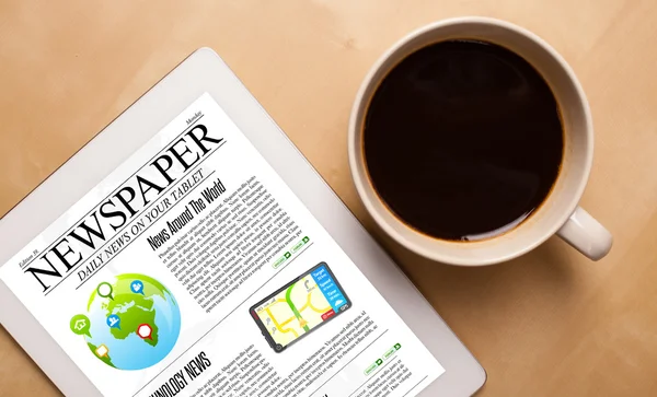 Tablet pc shows news on screen with a cup of coffee on a desk — Stock Photo, Image