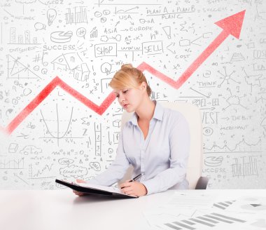 Piyasa diyagramlarıyla masada oturan iş kadını. 