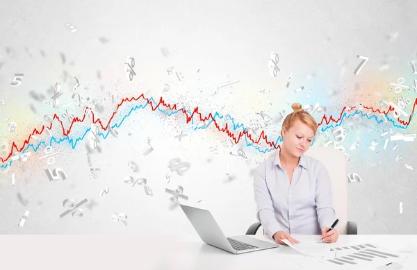 Деловая женщина сидит за столом с графиком фондового рынка — стоковое фото