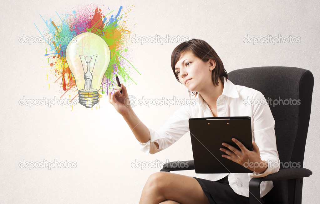 Young lady drawing a colorful light bulb with colorful splashes