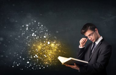Genç adam sihirli bir kitap okuyor.