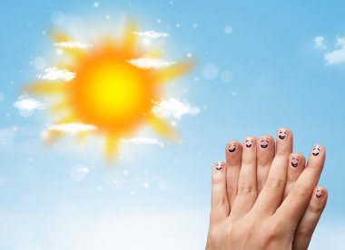 Parlak güneş ve bulutların çizdiği neşeli parmak gülümsemeleri