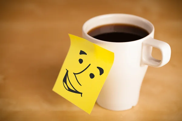 Nota post-it con la cara sonriente pegada en una taza — Foto de Stock