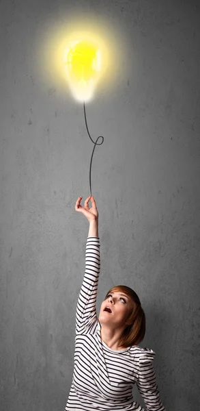 Frau hält einen Ballon mit Glühbirnen — Stockfoto