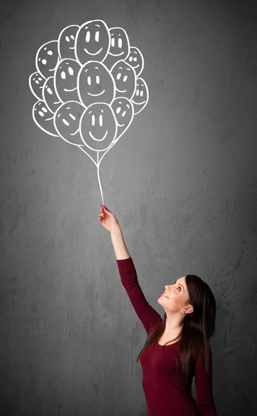 Woman holding a bunch of smiling balloons — Stock Photo, Image