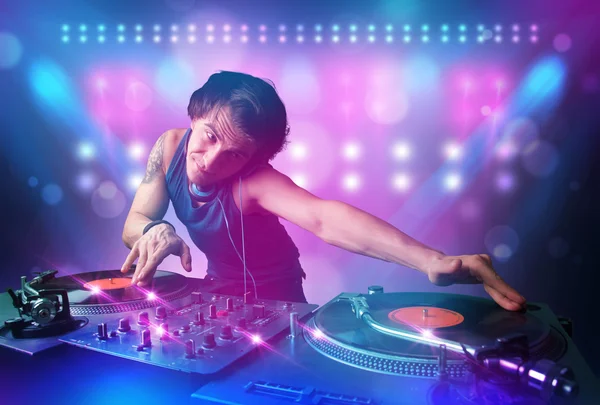 Disc jockey mixando musica sui giradischi sul palco con luci e — Foto Stock