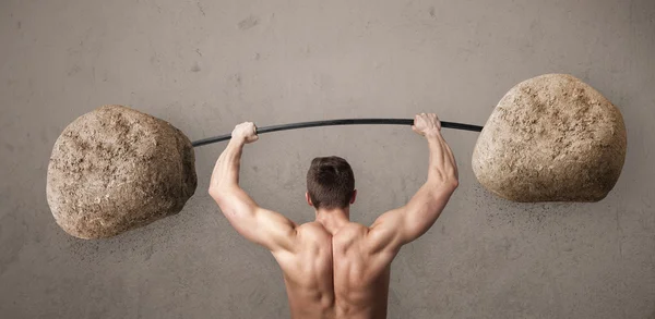 Muscular man lifting large rock stone weights — Stock Photo, Image