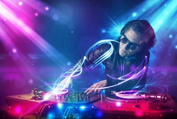 Energiska dj blandande musik med kraftfulla ljuseffekter — Stockfoto