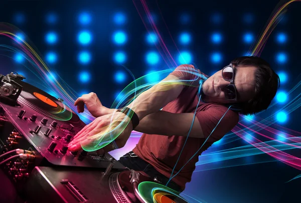 Young Dj mixing records with colorful lights — Stock Photo, Image