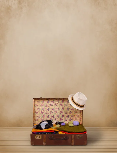 Bagages touristiques rétro avec vêtements colorés et copyspace — Photo