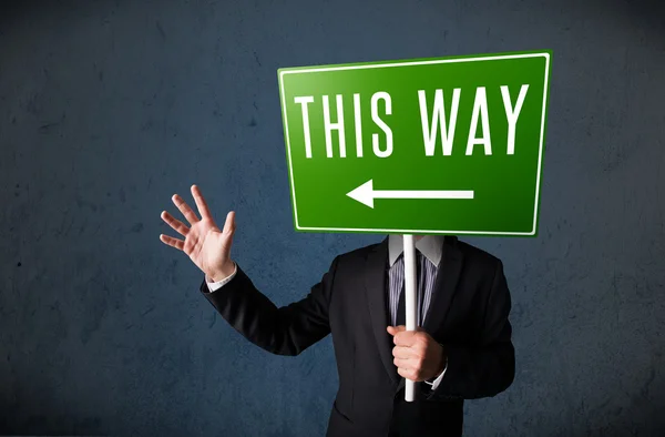 Businessman holding a direction sign — Stock Photo, Image