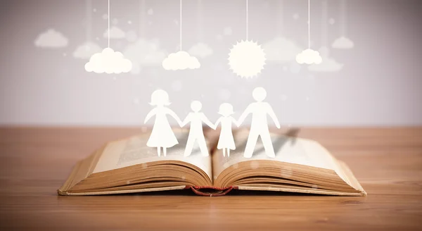 Cardboard figures of the family on opened book — Stock Photo, Image