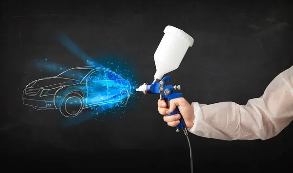 Worker with airbrush gun painting hand drawn car lines — Stock Photo, Image