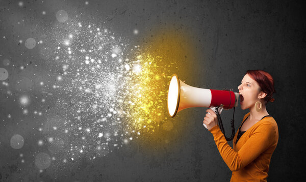 Женщина кричит в мегафон и исследует светящиеся частицы энергии
