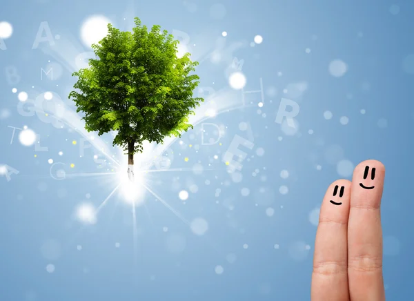 Счастливый палец улыбается с зеленым волшебным светящимся деревом — стоковое фото