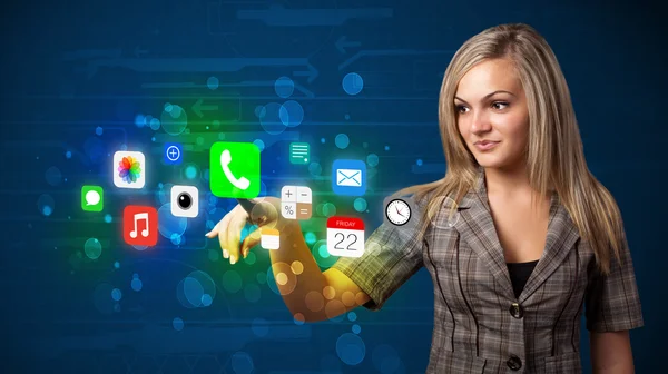 Young businesswoman pressing colorful mobile app icons with boke — Stock Photo, Image