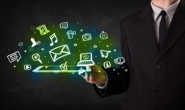 Person holding a tablet with media icons and symbols — Stock Photo, Image