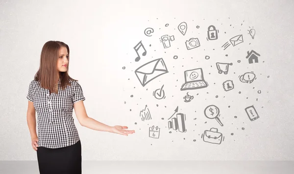 Young business woman presenting hand drawn media icons — Stock Photo, Image