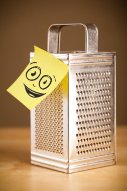 Yapışkan not ile gülen yüz rende yapışabilir