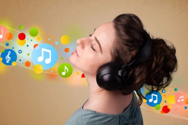 Kulaklıkla müzik dinleyen genç bir kadın. 