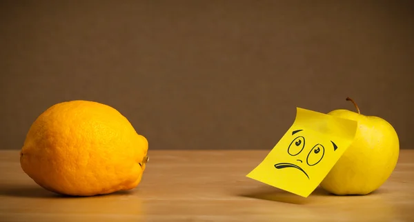 Pomme avec post-it collant regardant tristement le citron — Photo