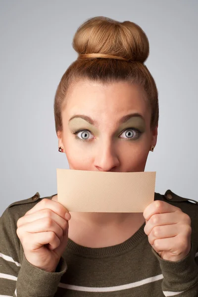 Linda chica sosteniendo la tarjeta blanca en frente de sus labios con spac copia — Foto de Stock