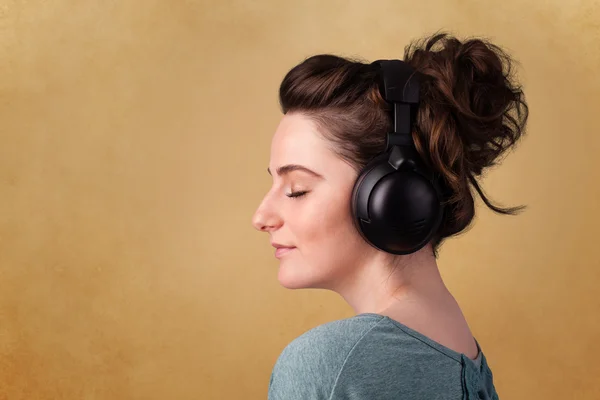 Young woman with headphones listening to music with copy space — Stock Photo, Image