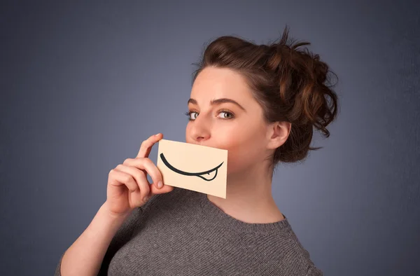 Menina bonita segurando cartão branco com desenho de sorriso — Fotografia de Stock