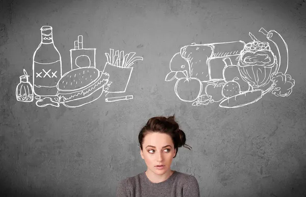 sağlıklı ve sağlıksız gıdalar arasında duran kadın