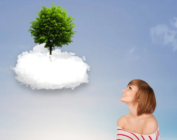 Niña apuntando a un árbol verde en la parte superior de una nube blanca — Foto de Stock