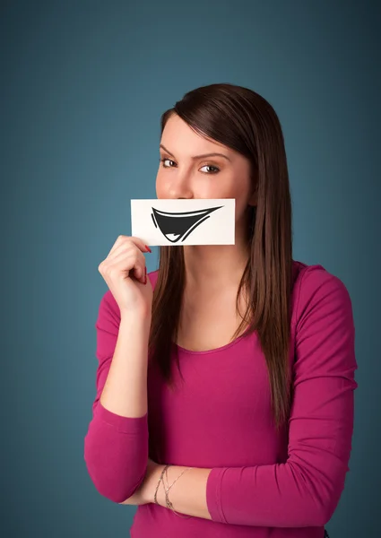 Feliz bonito menina segurando papel com engraçado smiley desenho — Fotografia de Stock