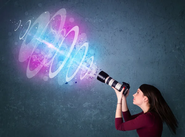 Fotógrafo chica haciendo fotos con haz de luz de gran alcance —  Fotos de Stock