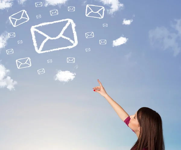 Young girl looking at mail symbol clouds on blue sky — Stock Photo, Image