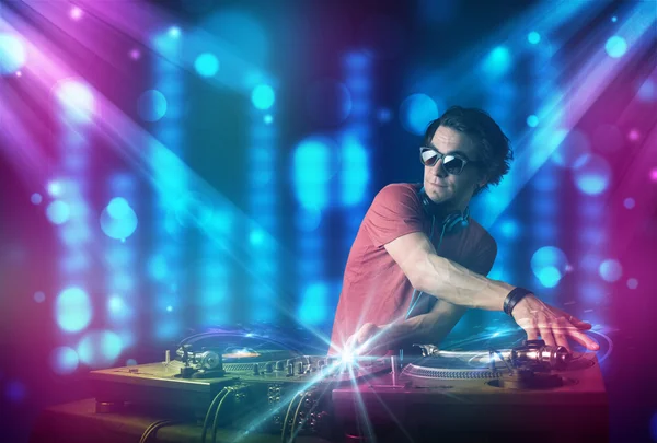DJ blandning musik i en klubb med blå och lila ljus — Stockfoto