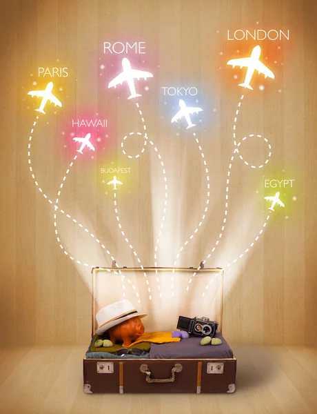 Travel bag with clothes and colorful planes flying out — Stock Photo, Image