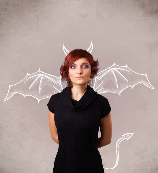 Девушка с дьявольскими рогами и рисованием крыльев — стоковое фото