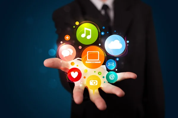 Young businessman presenting colorful technology icons and symbo — Stock Photo, Image
