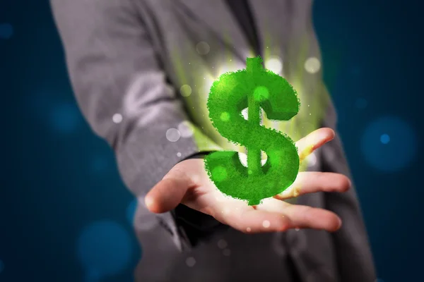 Young businessman presenting green glowing dollar sign — Stock Photo, Image