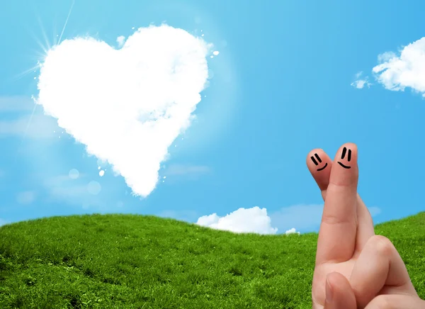 Happy smiley fingers looking at heart shaped cloud — Stock Photo, Image