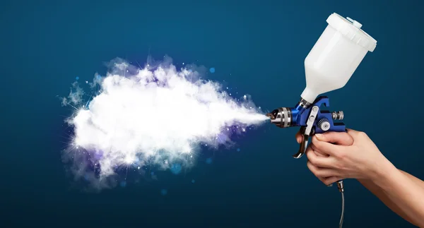 Schilder met airbrush pistool en witte magische rook — Stockfoto