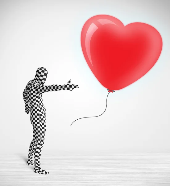 Χαριτωμένος τύπος με κοστούμι σώματος κοιτάζοντας μια καρδιά σε σχήμα μπαλονιού — Φωτογραφία Αρχείου
