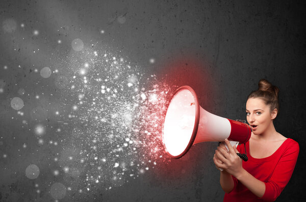 Женщина кричит в мегафон и исследует светящиеся частицы энергии
