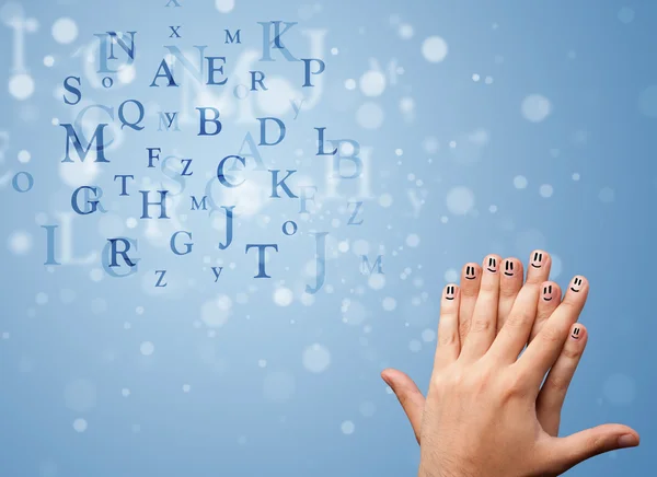 Happy smiley fingers looking at mixture of bokeh letters — Stock Photo, Image